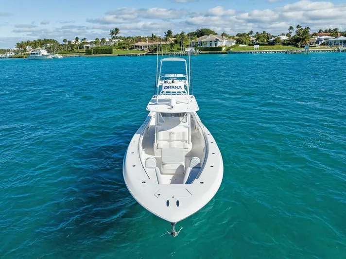 Ohana Yacht Photos Pics 2019 Invincible 42 Open Fisherman boat on clear blue water near a coastal neighborhood.
