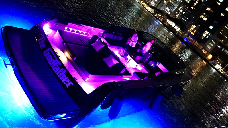 The Godfather Yacht Photos Pics VanDutch 55 yacht, 2014 model, illuminated with vibrant purple and blue lights on water.
