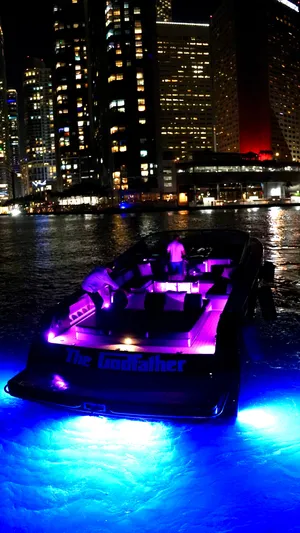 The Godfather Yacht Photos Pics VanDutch 55 yacht with vibrant lights against city skyline at night, 2014 model.