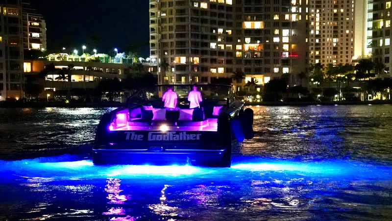 The Godfather Yacht Photos Pics VanDutch 55 yacht, 2014 model, illuminated at night with vibrant blue lights on the water.