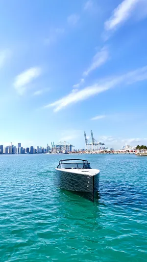 The Godfather Yacht Photos Pics VanDutch 55 yacht on clear blue water with city skyline and cranes in the background.