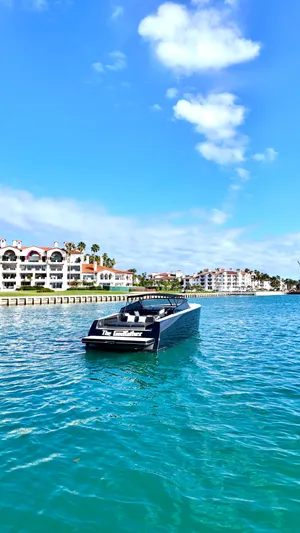 The Godfather Yacht Photos Pics Luxurious 2014 VanDutch 55 yacht cruising near waterfront homes under a clear blue sky.