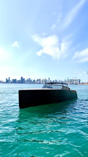 The Godfather Yacht Photos Pics 2014 VanDutch 55 yacht on turquoise water with city skyline in the background.