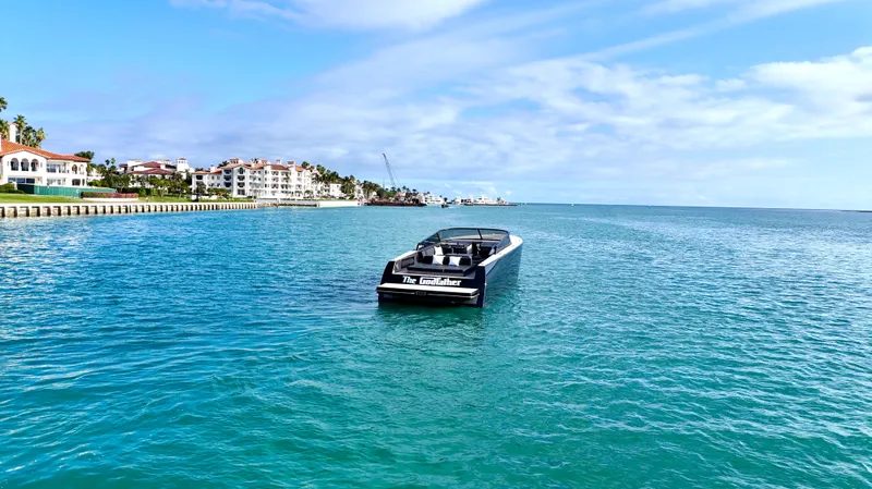 The Godfather Yacht Photos Pics VanDutch 55 yacht cruising on clear blue waters, 2014 model, with coastal buildings in the background.