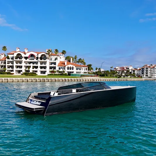 The Godfather Yacht Photos Pics 2014 VanDutch 55 yacht on clear blue water near luxury waterfront homes.