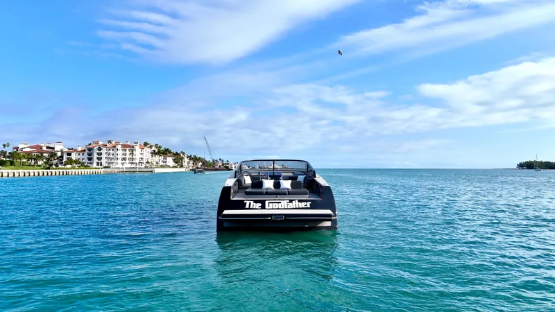 The Godfather Yacht Photos Pics 2014 VanDutch 55 yacht named "The Godfather" on serene blue waters, coastal buildings in background.
