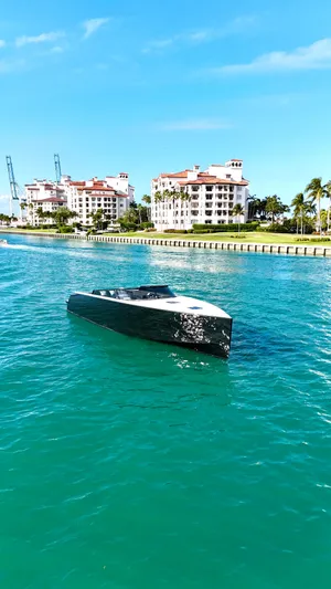 The Godfather Yacht Photos Pics 2014 VanDutch 55 yacht cruising in turquoise waters near luxury waterfront buildings.