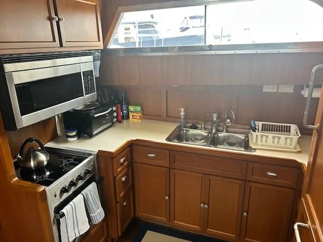 Day Light Yacht Photos Pics Galley kitchen in 1968 Hatteras 58 CPMY yacht with wood cabinets and modern appliances.