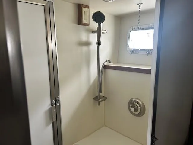 Day Light Yacht Photos Pics Shower area in 1968 Hatteras 58 CPMY yacht, featuring modern fixtures and a small window.