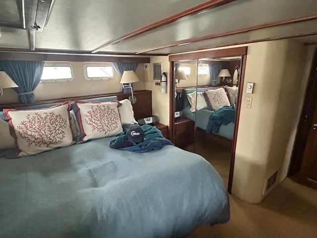 Day Light Yacht Photos Pics Luxurious bedroom interior of 1968 Hatteras 58 CPMY yacht with blue bedding and mirrored closet.