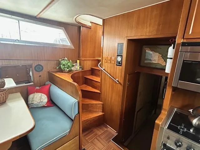 Day Light Yacht Photos Pics 1968 Hatteras 58 CPMY interior with wooden stairs, seating, and kitchen area.