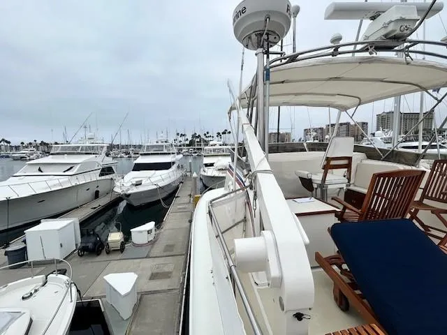 Day Light Yacht Photos Pics 1968 Hatteras 58 CPMY yacht docked at marina with wooden deck chairs.