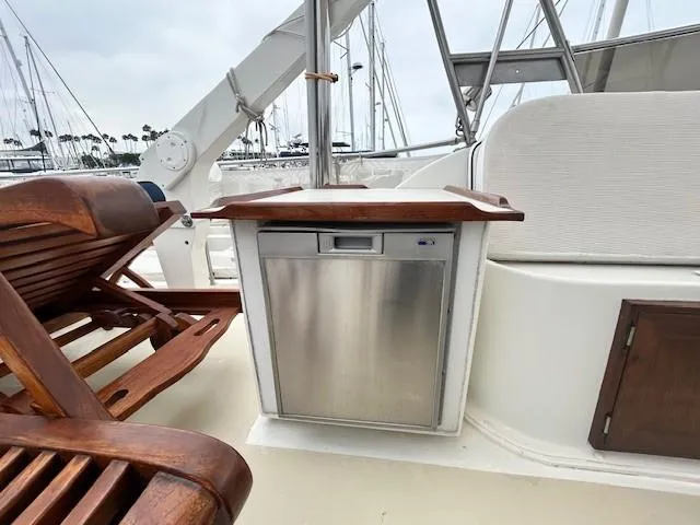 Day Light Yacht Photos Pics 1968 Hatteras 58 CPMY yacht deck with wooden seating and stainless steel cabinet.