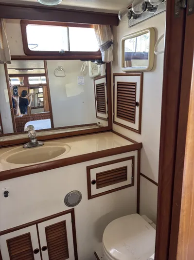 Day Light Yacht Photos Pics 1968 Hatteras 58 CPMY yacht bathroom with wooden accents and compact design.