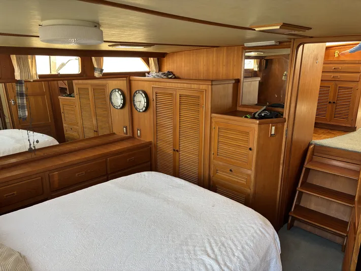 Day Light Yacht Photos Pics Interior of 1968 Hatteras 58 CPMY yacht with wooden cabinetry and white bedding.