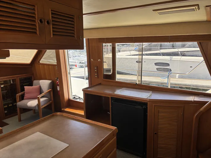 Day Light Yacht Photos Pics Interior of 1968 Hatteras 58 CPMY yacht with wooden cabinetry and marina view.