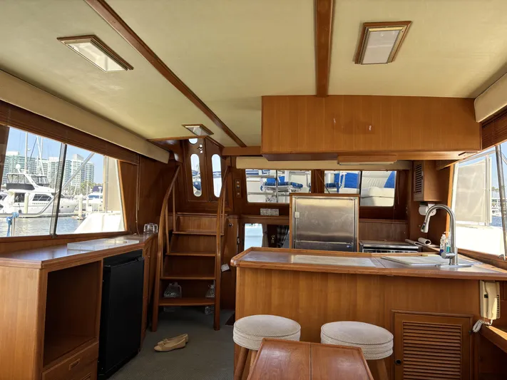 Day Light Yacht Photos Pics Interior of 1968 Hatteras 58 CPMY yacht with wooden cabinetry and marina view.