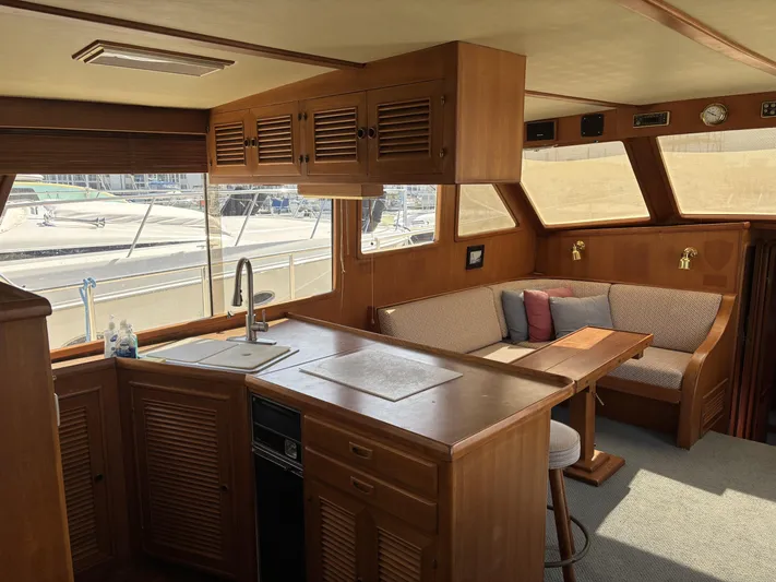 Day Light Yacht Photos Pics Interior of 1968 Hatteras 58 CPMY yacht with wooden cabinetry and seating area.