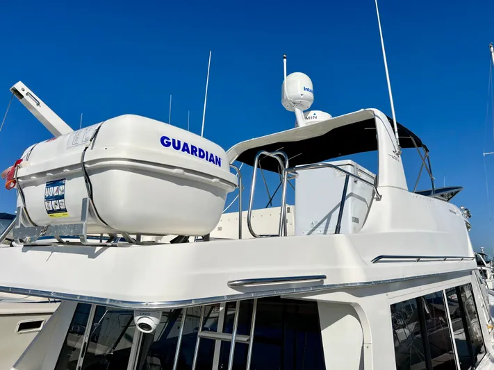 Mamba Mentality Yacht Photos Pics 2008 Meridian 490 Pilothouse yacht with lifeboat on deck, under clear blue sky.