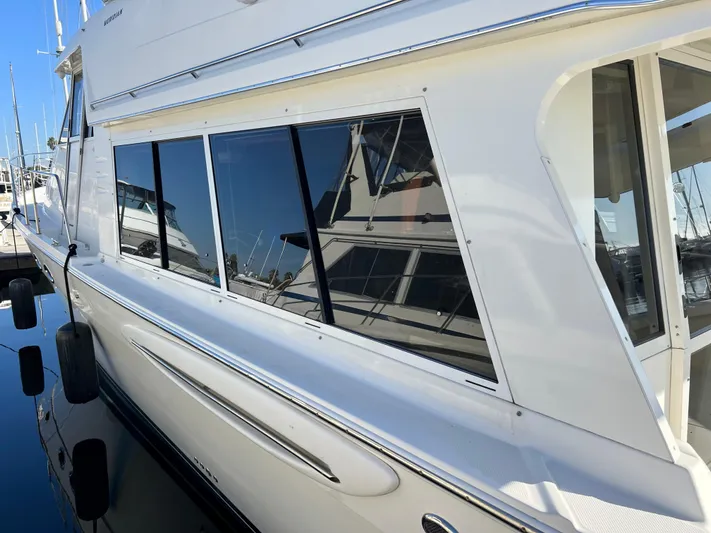 Mamba Mentality Yacht Photos Pics 2008 Meridian 490 Pilothouse yacht docked, reflecting nearby boats on its windows.
