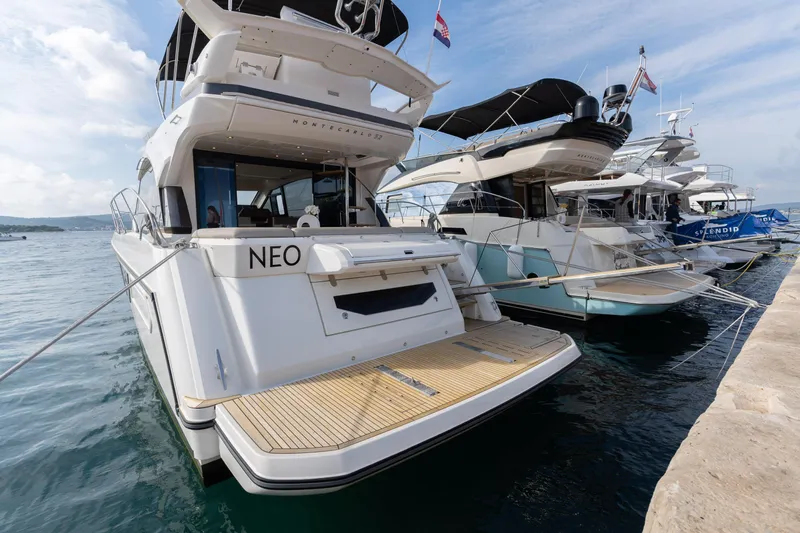  Yacht Photos Pics 2022 Beneteau Monte Carlo 52 yacht docked, showcasing sleek design and spacious deck.
