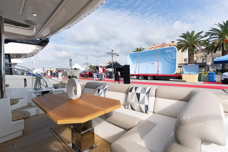  Yacht Photos Pics Luxurious 2022 Beneteau Monte Carlo 52 yacht interior with elegant seating and wooden table.