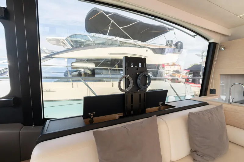  Yacht Photos Pics Interior view of 2022 Beneteau Monte Carlo 52 yacht with modern seating and window.