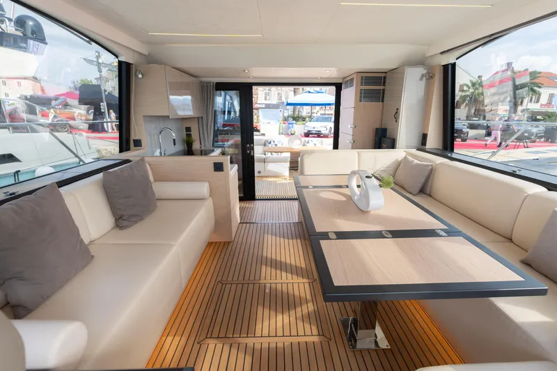  Yacht Photos Pics Luxurious interior of 2022 Beneteau Monte Carlo 52 yacht with elegant seating and dining area.