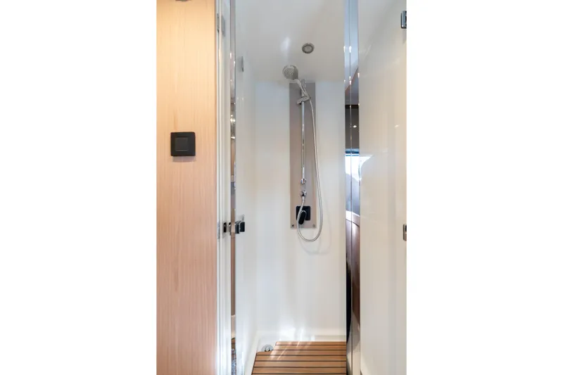  Yacht Photos Pics Shower area in 2022 Beneteau Monte Carlo 52 yacht, featuring modern fixtures and wooden flooring.