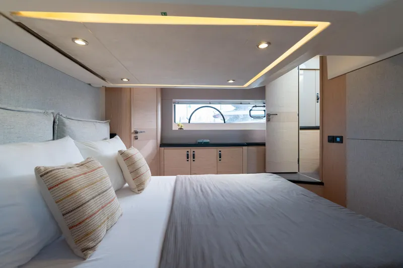  Yacht Photos Pics Luxurious bedroom interior of 2022 Beneteau Monte Carlo 52 yacht, featuring modern design and cozy bedding.