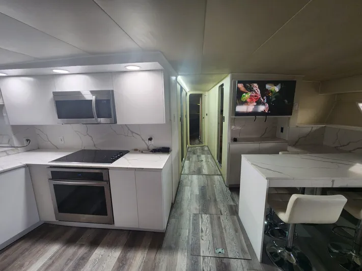  Yacht Photos Pics Modern kitchen and dining area in 1984 Infinity Express RV with sleek white cabinetry.