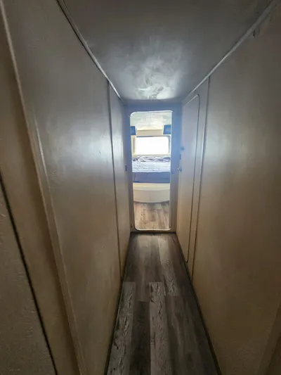  Yacht Photos Pics Narrow hallway in 1984 Infinity Express RV leading to a bedroom with wood flooring.