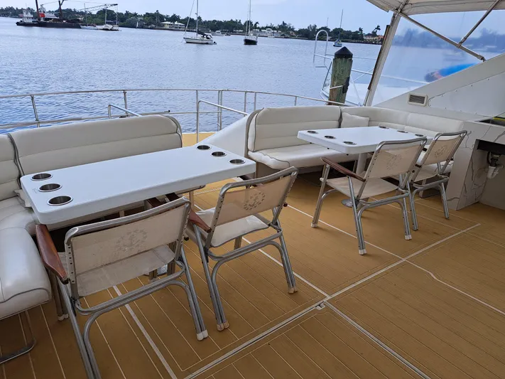  Yacht Photos Pics Luxury seating area on the deck of a 1984 Infinity Express yacht, overlooking a serene waterfront.