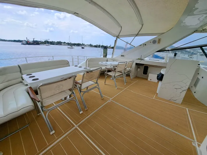  Yacht Photos Pics Luxury deck of 1984 Infinity Express yacht with seating and tables, overlooking calm waters.