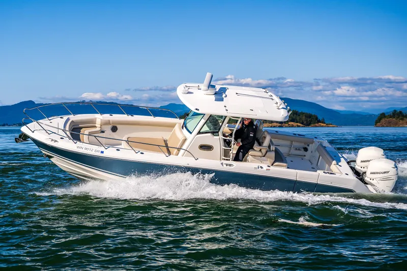  Yacht Photos Pics 2017 Boston Whaler 330 Outrage cruising on open water with scenic island backdrop.