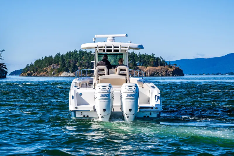  Yacht Photos Pics 2017 Boston Whaler 330 Outrage cruising near scenic island landscape.