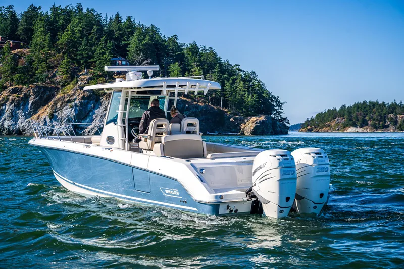  Yacht Photos Pics 2017 Boston Whaler 330 Outrage boat cruising near scenic rocky coastline.