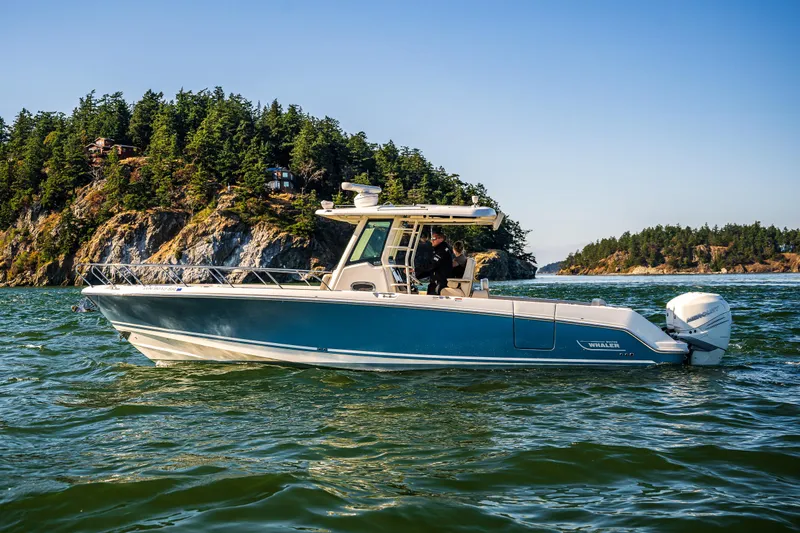  Yacht Photos Pics 2017 Boston Whaler 330 Outrage boat cruising near scenic rocky coastline.