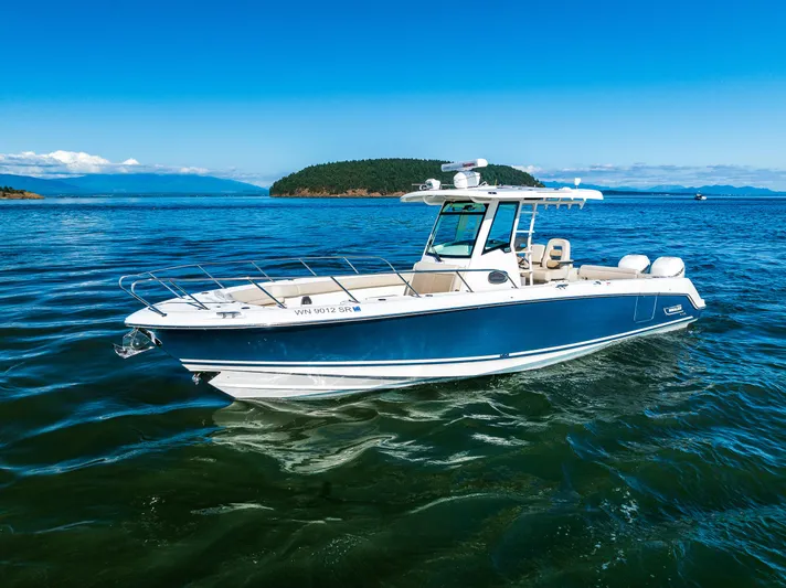  Yacht Photos Pics 2017 Boston Whaler 330 Outrage boat on calm blue water under clear sky.