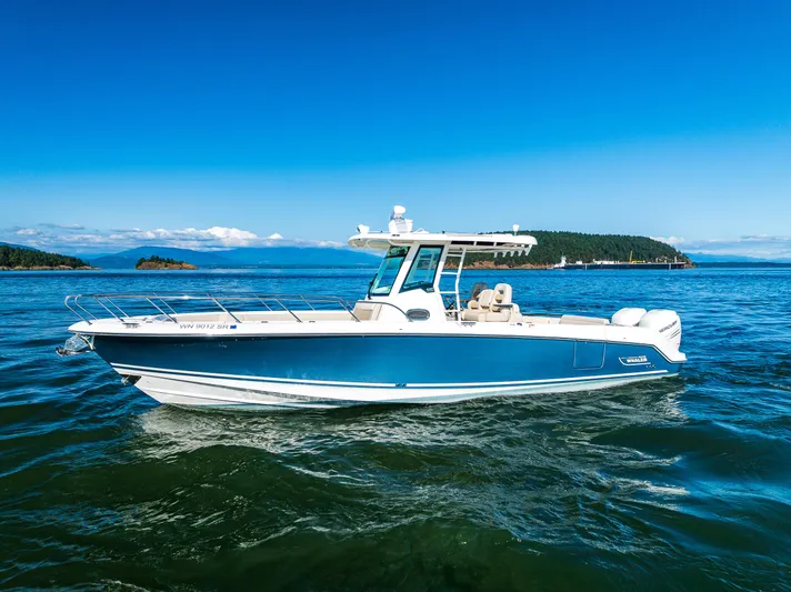  Yacht Photos Pics 2017 Boston Whaler 330 Outrage boat cruising on blue ocean near scenic islands.