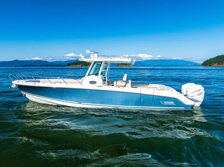  Yacht Photos Pics 2017 Boston Whaler 330 Outrage boat on calm blue waters, scenic background.