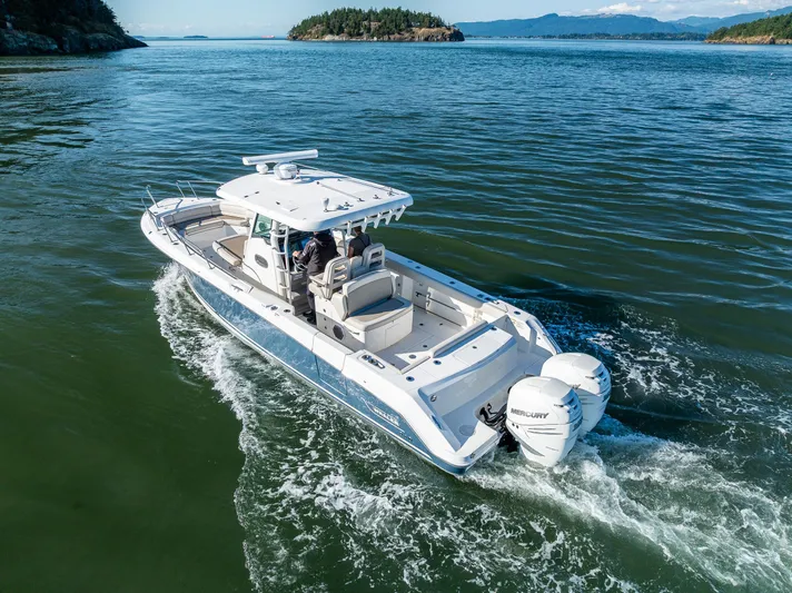  Yacht Photos Pics 2017 Boston Whaler 330 Outrage cruising on open water, showcasing sleek design and powerful engines.