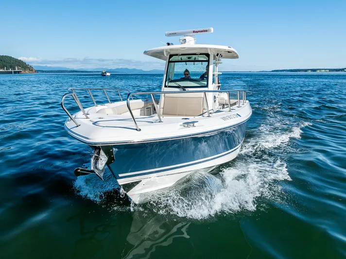  Yacht Photos Pics 2017 Boston Whaler 330 Outrage cruising on open water under clear blue skies.