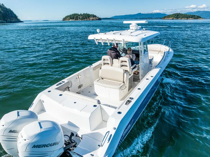  Yacht Photos Pics 2017 Boston Whaler 330 Outrage cruising on open water with scenic island backdrop.