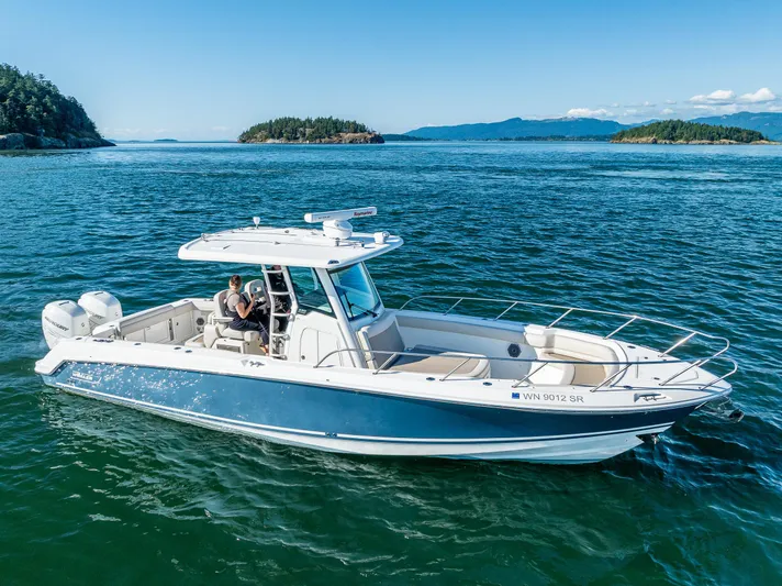  Yacht Photos Pics 2017 Boston Whaler 330 Outrage cruising on clear blue waters, surrounded by scenic islands.