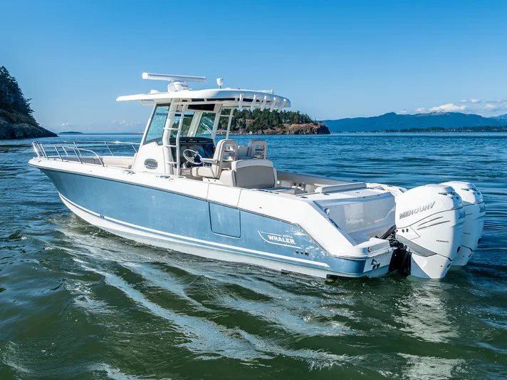  Yacht Photos Pics 2017 Boston Whaler 330 Outrage boat cruising on open water with scenic background.
