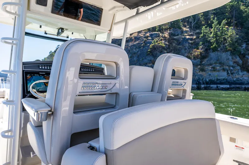  Yacht Photos Pics 2017 Boston Whaler 330 Outrage boat interior with plush seating and navigation system.