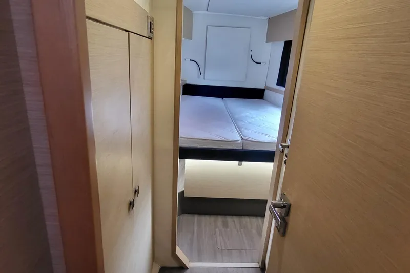 Knot On Call Yacht Photos Pics Interior cabin of 2018 Fountaine Pajot Helia 44 catamaran, featuring a cozy bed and wooden finishes.
