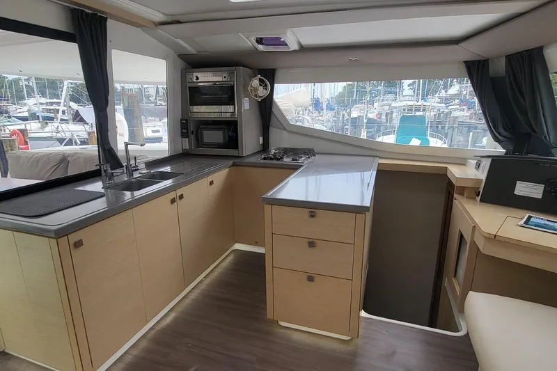 Knot On Call Yacht Photos Pics Modern kitchen interior of 2018 Fountaine Pajot Helia 44 catamaran, featuring sleek cabinetry and appliances.