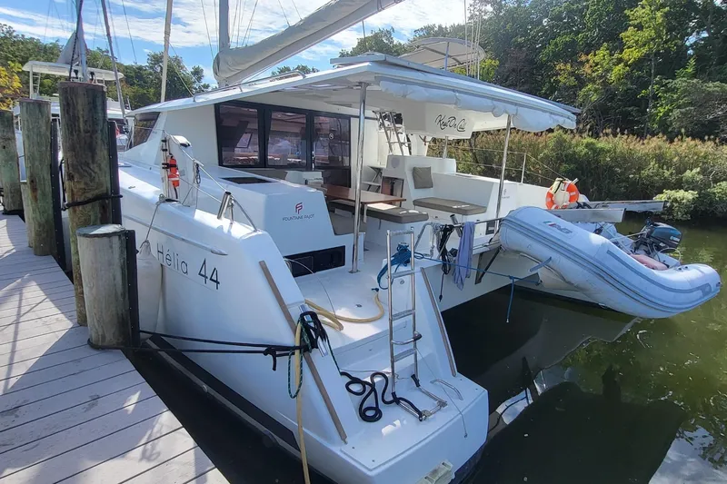 Knot On Call Yacht Photos Pics 2018 Fountaine Pajot Helia 44 catamaran docked with inflatable dinghy attached.
